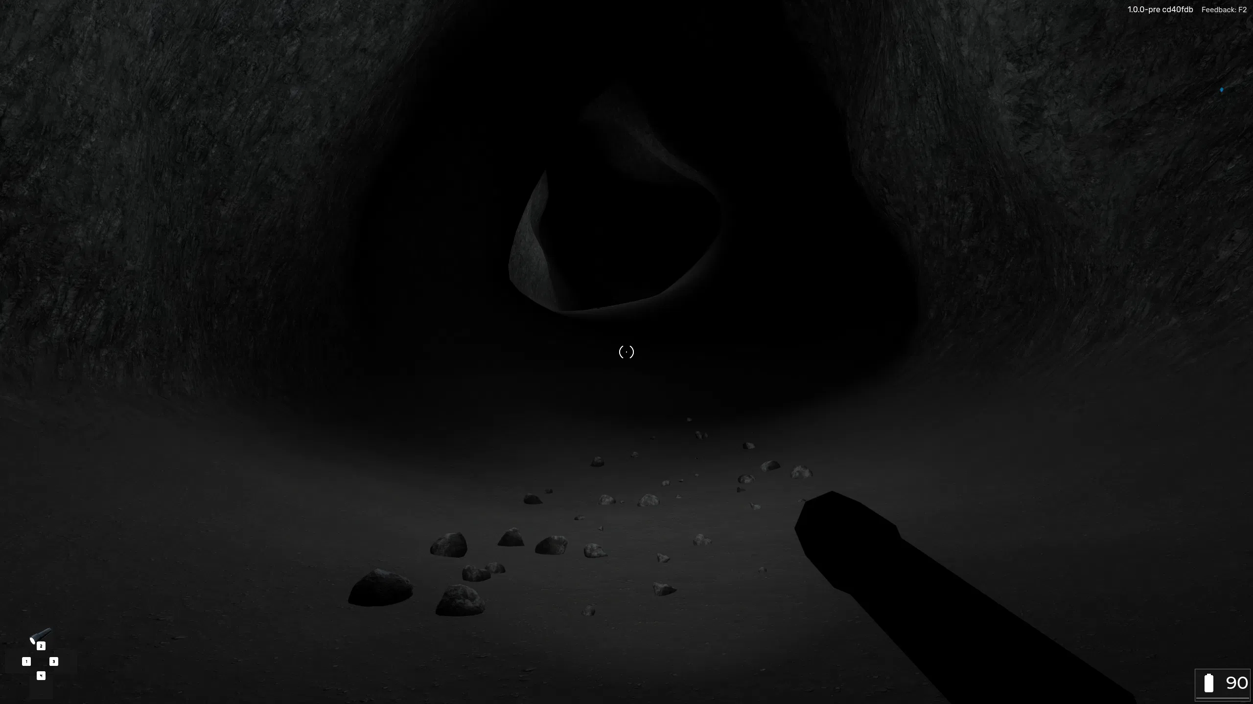 A first-person view inside a dark lavatube, where the player's flashlight illuminates a trail of small rocks on the cave floor.